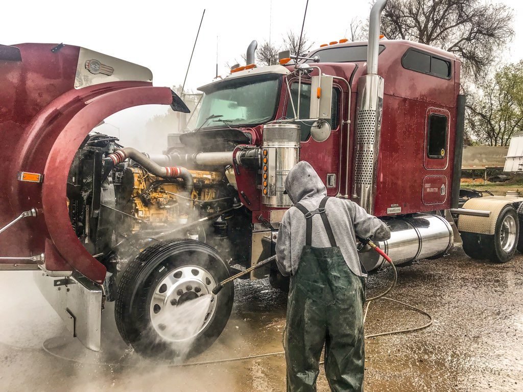 Pressure washing a semi truck engine bay on site